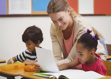 Female teacher helping girl